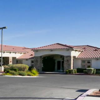 A single-story building with a tiled roof and landscaped entrance.