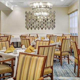 A well-arranged dining area with elegant chandeliers and striped chairs.