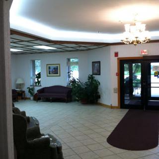 A spacious and well-lit lobby featuring comfortable seating and decorative plants.