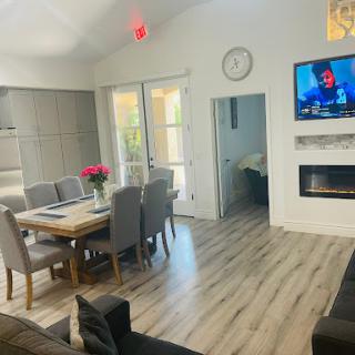 A cozy and modern living space featuring a dining area, a comfortable sofa, and a wall-mounted television.