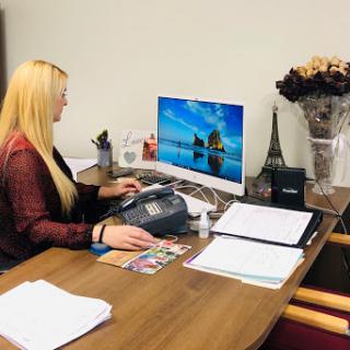 A woman working at her office desk with a computer and documents.