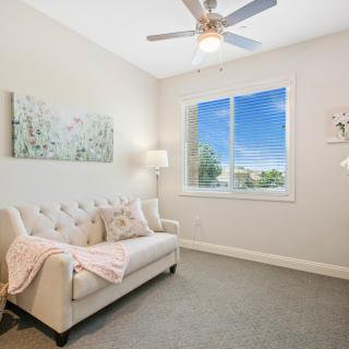 A cozy living room with a sofa, brightened by natural light from the window.