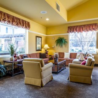 A cozy living room with comfortable sofas and armchairs arranged around a coffee table.