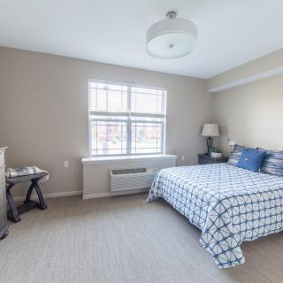 A clean and bright bedroom with a neatly made bed.