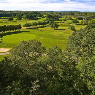 A scenic view of a lush golf course with vibrant greenery and well-manicured landscapes.