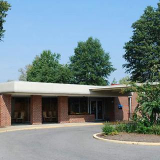 A building entrance surrounded by trees with a circular driveway.