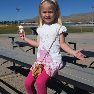A cheerful child enjoying ice cream on a sunny day at the playground.