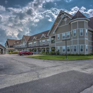 A large, multi-story building with a cloudy sky in the background.