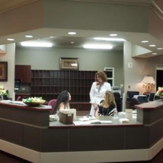 A professional reception area where people are interacting at a desk.
