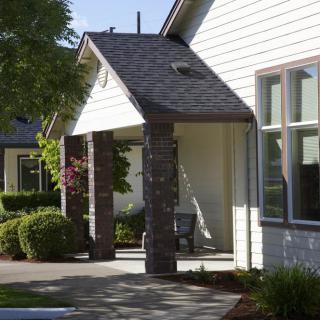 A charming suburban house with a small porch and neat landscaping.