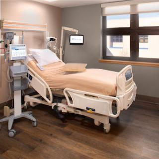 A well-equipped patient room in a modern hospital, featuring a medical bed and essential monitoring equipment.