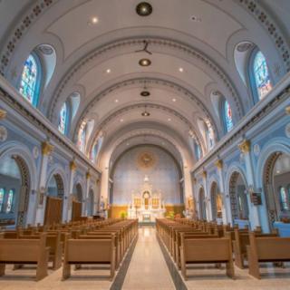 Interior view of a church with wooden pews and an arched ceiling.