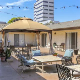 A cozy patio with a gazebo and comfortable seating in an urban setting.
