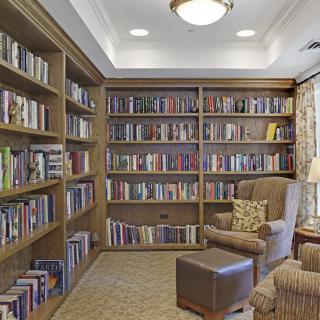 A cozy library corner with bookshelves filled with books and a comfortable armchair for reading.