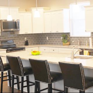A modern kitchen with a spacious countertop and stylish bar stools.