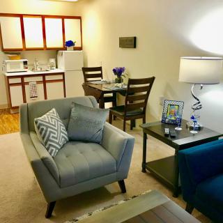 A cozy apartment living area with comfortable seating and a kitchenette.