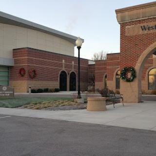 A view of a building featuring holiday wreaths, showcasing brick architecture in a serene outdoor setting.