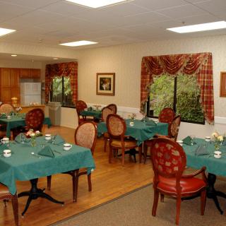 A cozy dining room with tables and chairs arranged in a warm, inviting setting.
