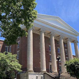 A majestic building featuring grand columns under a clear blue sky.