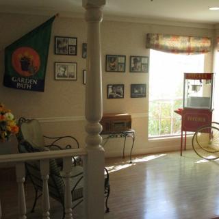A cozy living room with vintage decor, sunlight streaming in through the window, and a popcorn machine in the corner.