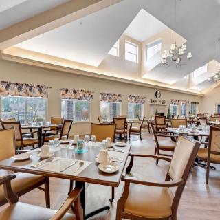 A spacious dining area with neatly arranged tables and chairs under a well-lit ceiling.