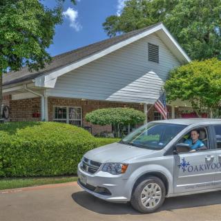 A vehicle parked in front of a house with an American flag visible.
