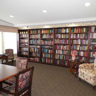 A cozy library with shelves filled with books and comfortable seating.