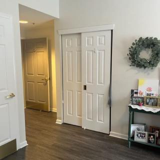 A hallway with sliding doors and a decorative wreath on the wall.