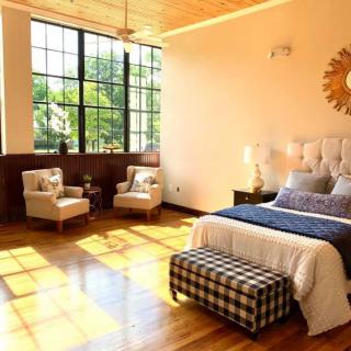 A bright and airy bedroom with modern decor and large windows allowing ample natural light.