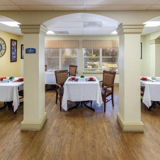An elegantly set dining area with tables and chairs in a cozy indoor setting.