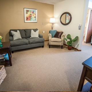 A cozy living room with a sofa, armchair, and decorative items.