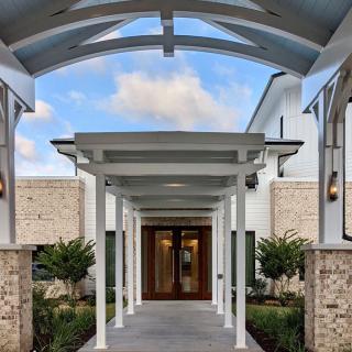 A modern entrance walkway with white columns and a covered roof leading to a building.