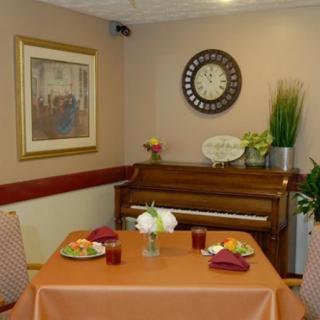 A cozy dining area with a piano, complete with a decorated table and wall art.