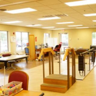 A well-equipped physical therapy and rehabilitation room with exercise equipment and therapy stations.