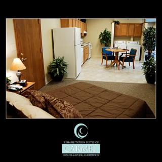 A cozy studio apartment featuring a bed, kitchenette, and dining area.