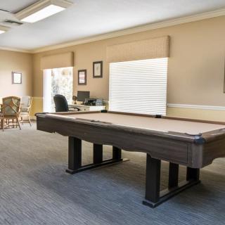A spacious game room featuring a pool table and an office area.