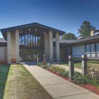 A modern building with a prominent entrance and landscaped walkway.