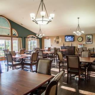 A spacious dining area with elegant lighting and large windows.