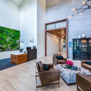 A modern lobby with stylish furniture and a prominent painting on the wall.
