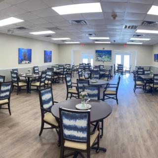 A spacious dining hall with neatly arranged tables and chairs.