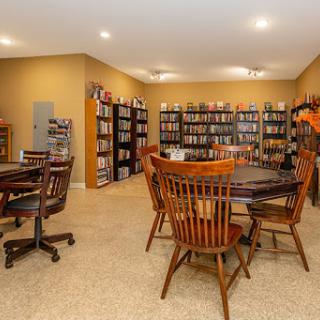 A cozy library space featuring shelves filled with books and comfortable seating for reading.