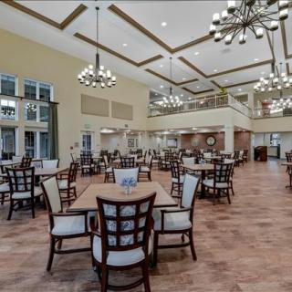 Spacious dining area with elegant chandeliers and neatly arranged tables and chairs.