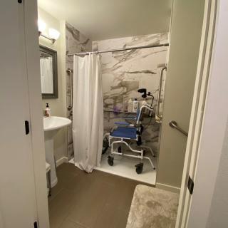 A clean bathroom with a shower, sink, and mirror.