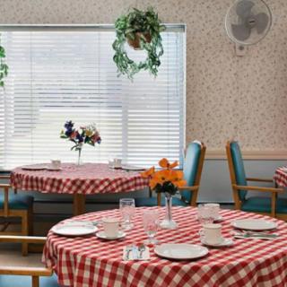 A cozy dining area with checkered tablecloths and floral decorations.