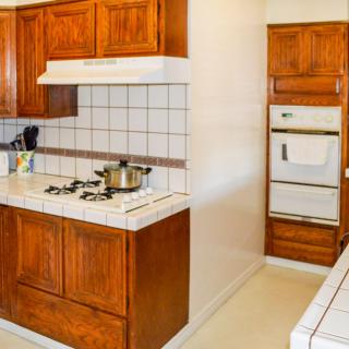 A kitchen with wooden cabinets, a stovetop, and an oven.