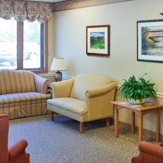 Cozy living room with sofas, chairs, and framed art on the walls.
