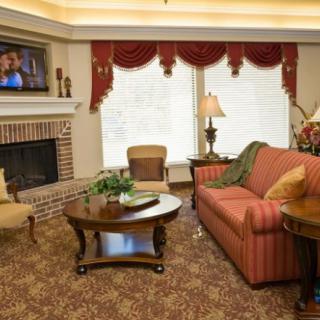 A cozy living room with a fireplace, sofa, and elegant decor.