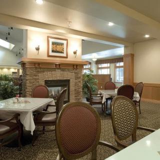 A cozy dining area with a fireplace, featuring elegantly set tables and chairs.