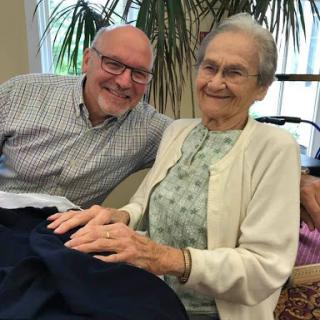 A heartwarming moment between a smiling elderly woman and her companion, sharing joy and connection.