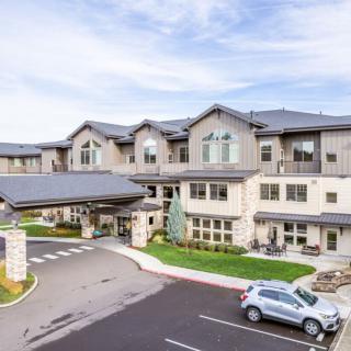 A modern residential building with a parking area in front.